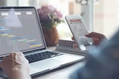 person checking phone calendar with computer calendar in background